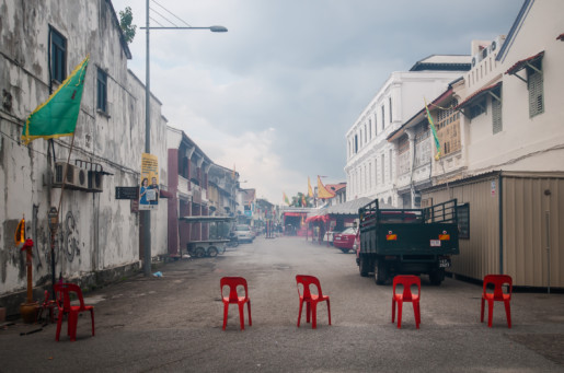 red chairs in the middle of a smokey street in penang